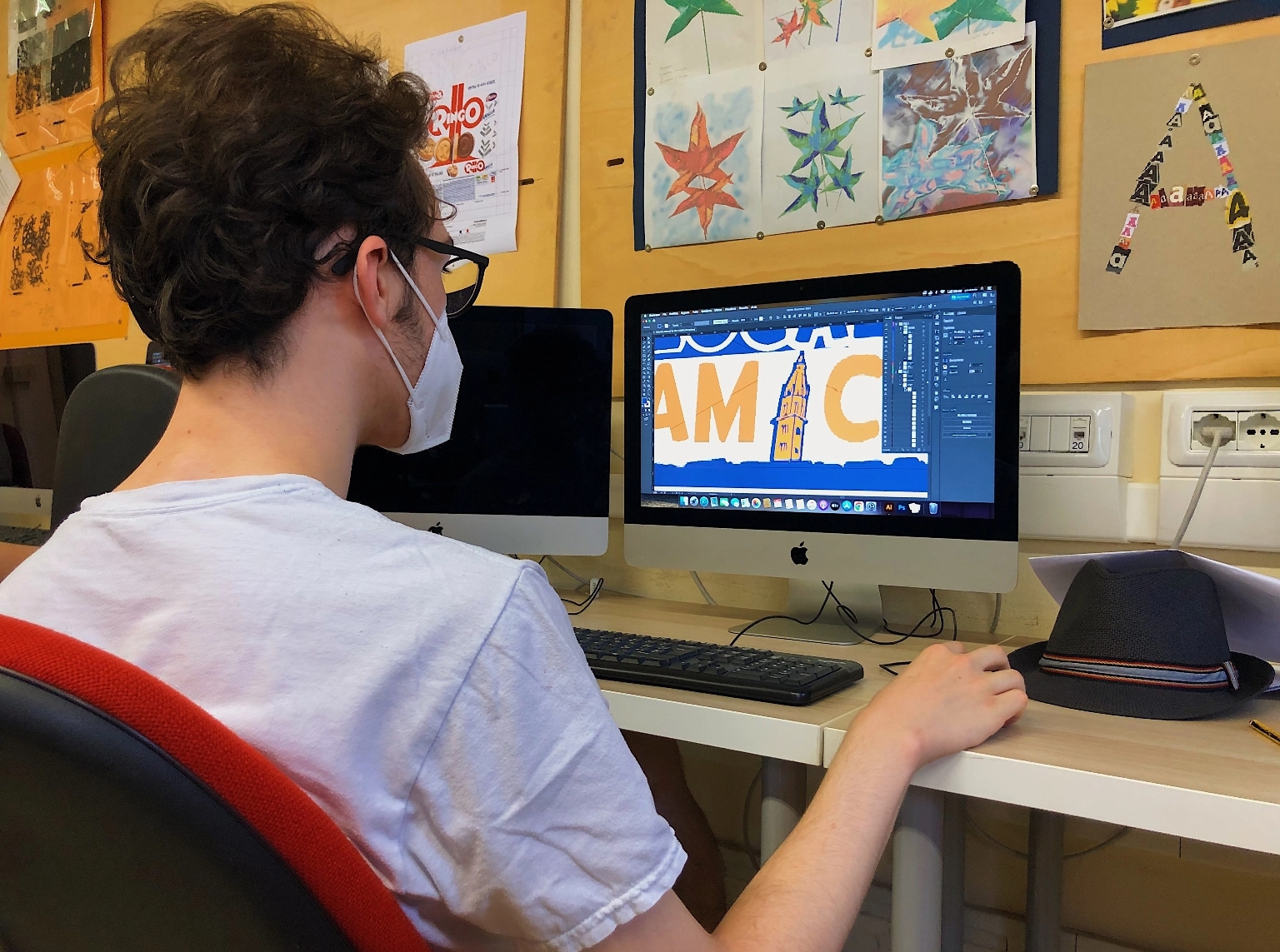 Un ragazzo davanti ad un computer mentre lavora sul logo del progetto Locale Amico.